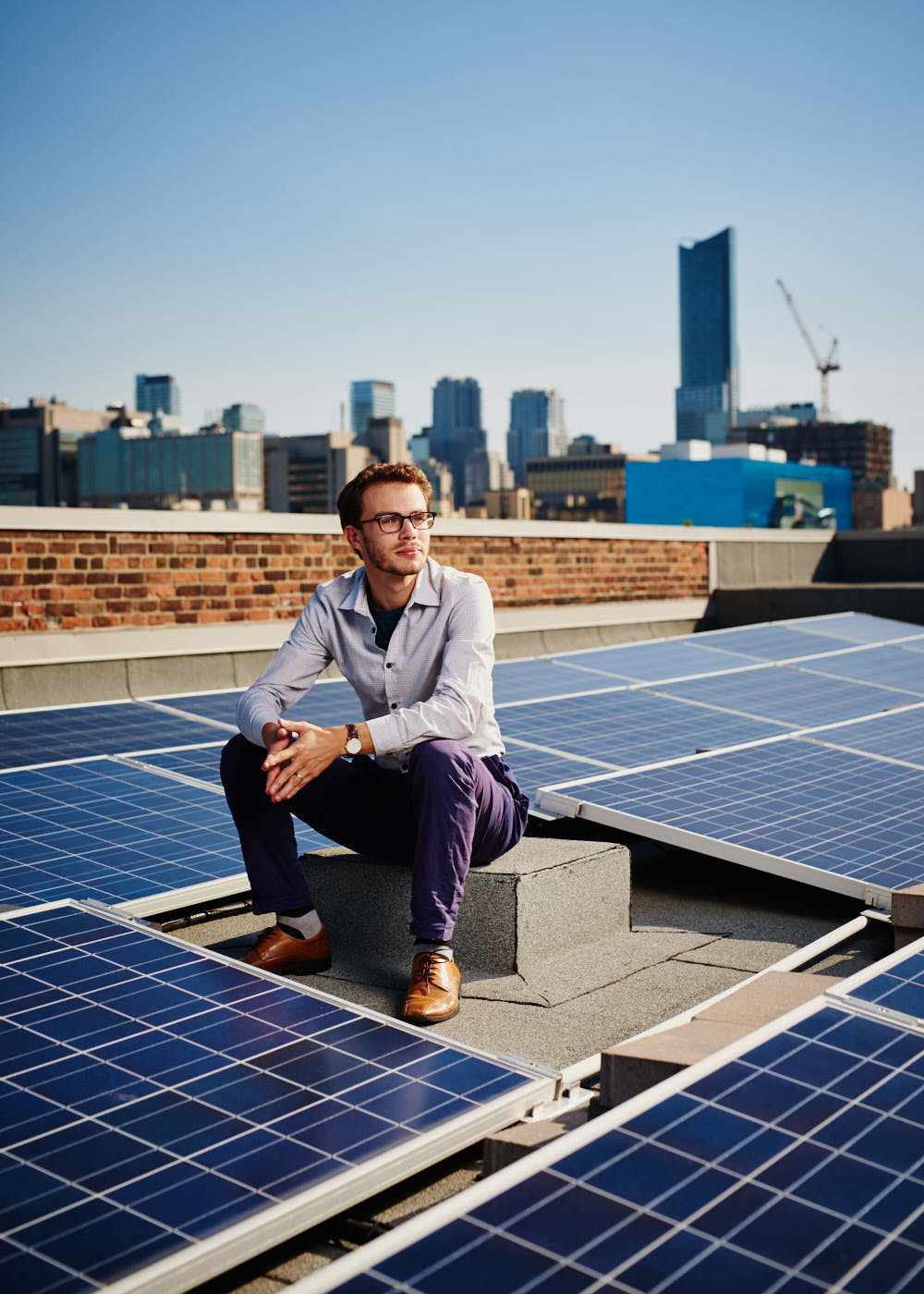 business-executive-sitting-on-roof-with-solar-panels