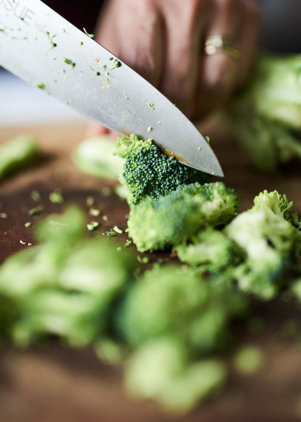 Close-up of knife chopping brocolli for Toronto small business wellness company