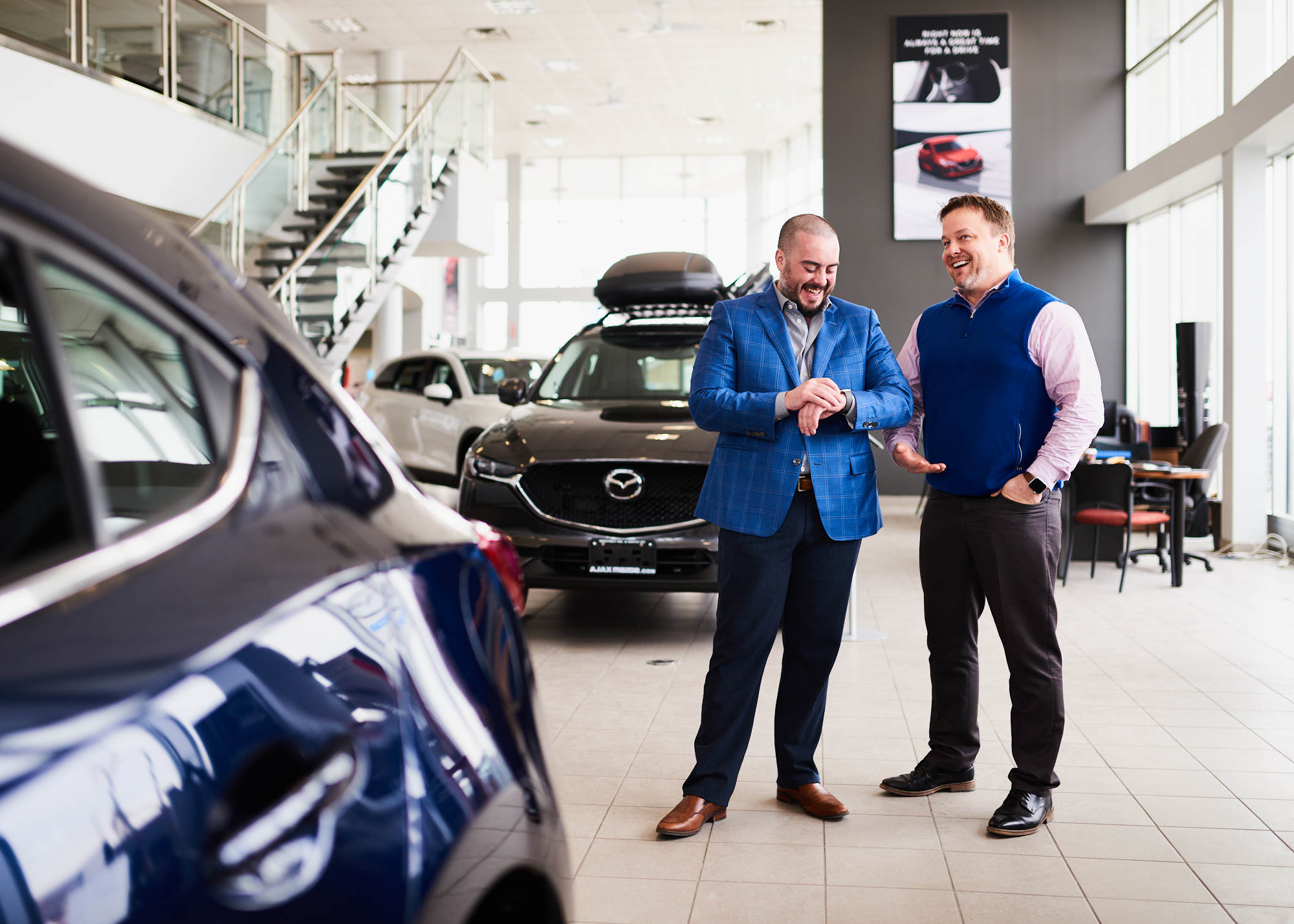Editorial photograph of two small business owners in car dealership