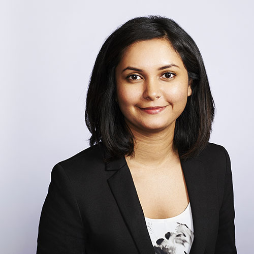 Toronto studio business headshot of young female investment executive on grey background