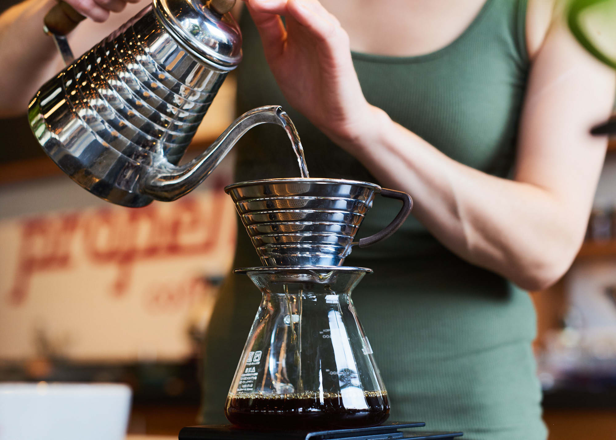 Close-up lifestyle photograph of Toronto small business barista pouring coffee